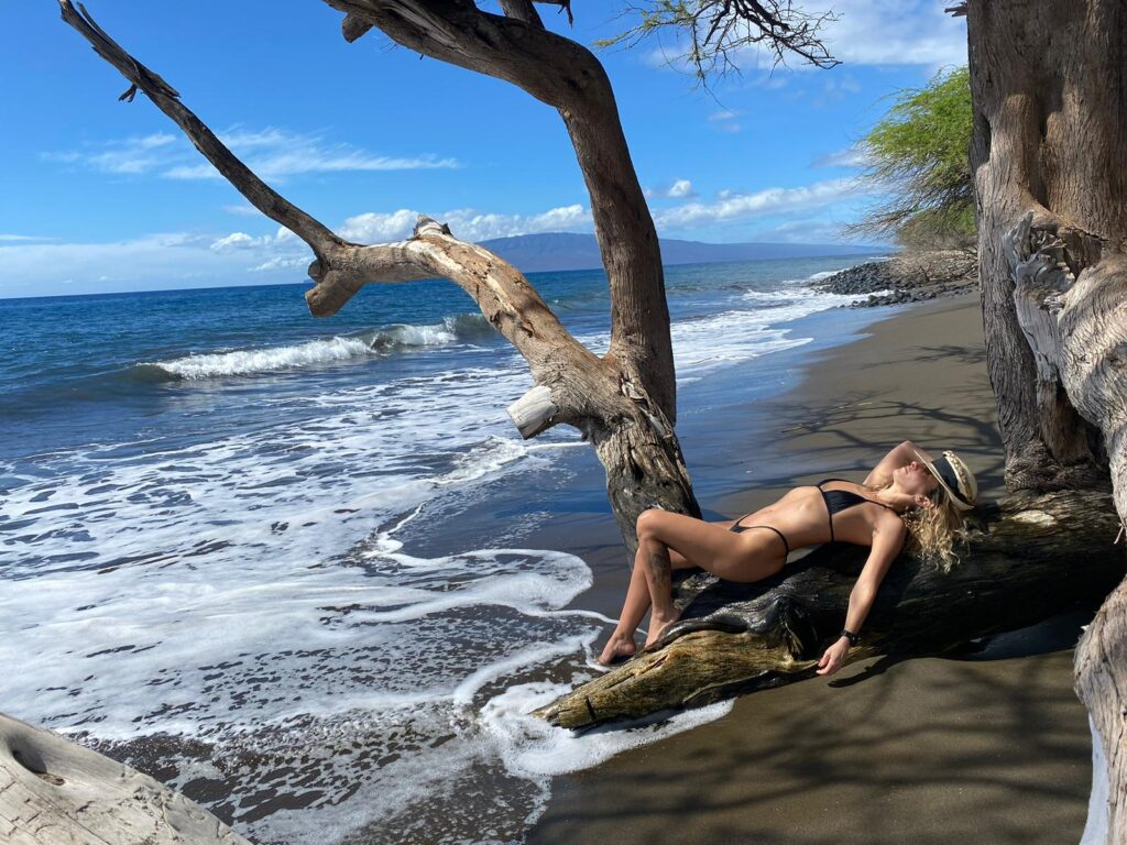 modeling black bikini on a tree on the beach in Hawaii.